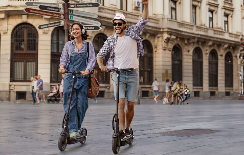 a girl and a man ride on e-scooter