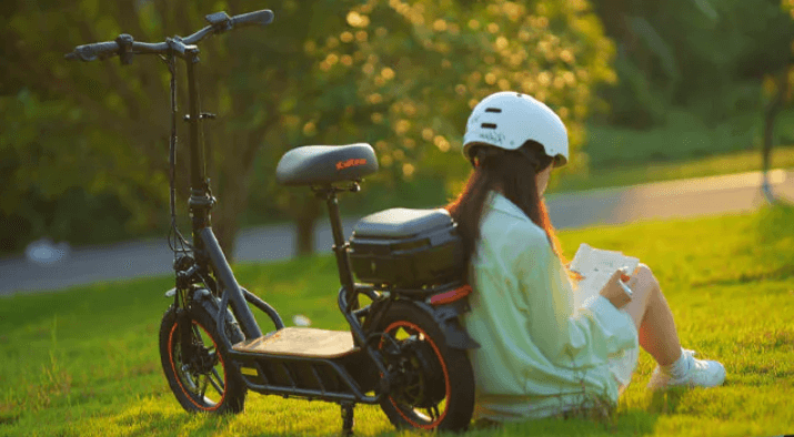 a girl sits near kukirin c1 pro electric scooter