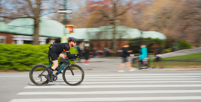 a man wearing a helmet riding a bicycle on the road