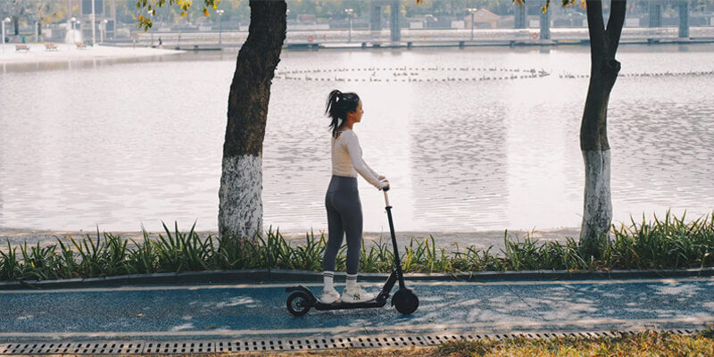 a woman rides e-scooter kukirin s3-pro