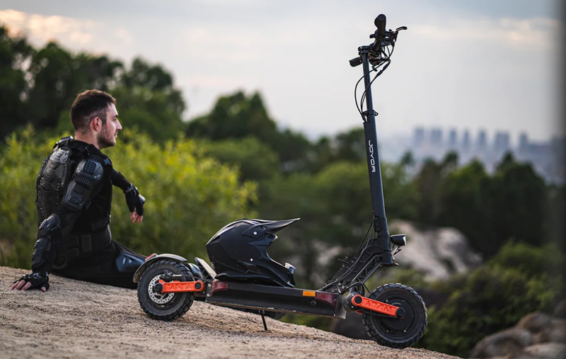 a man sits near e-scooter 