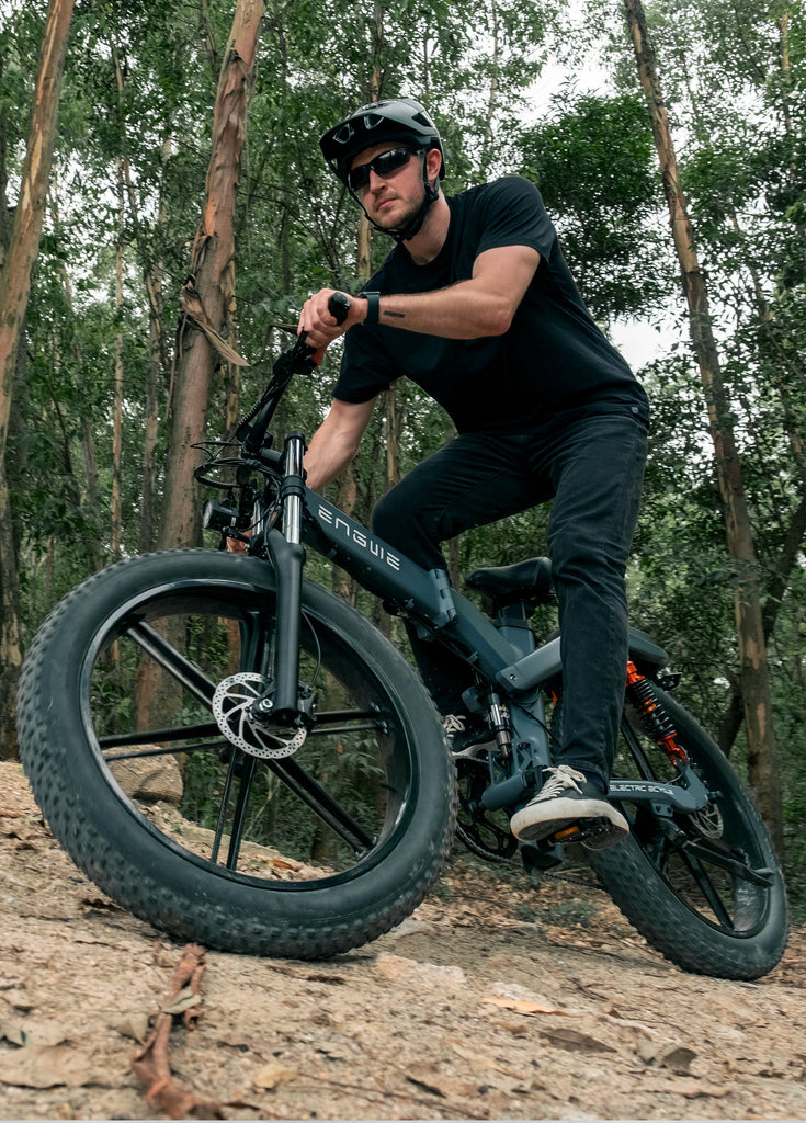 a man rides an engwe x26 on a rough trail