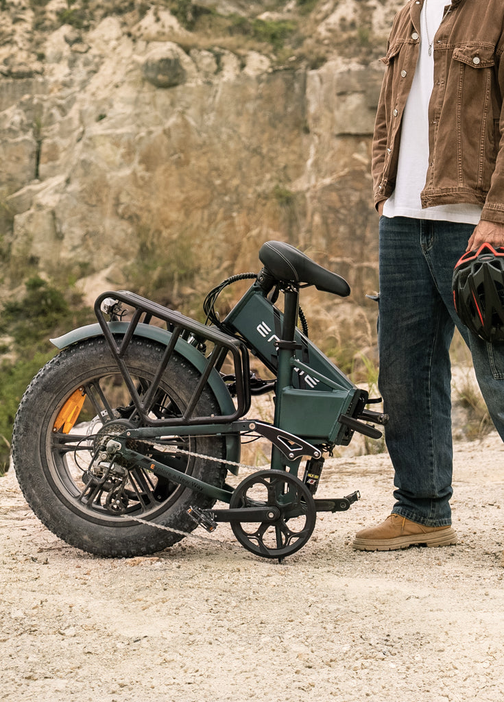 a man stands near the collapsible electric bike engwe engine pro 2.0